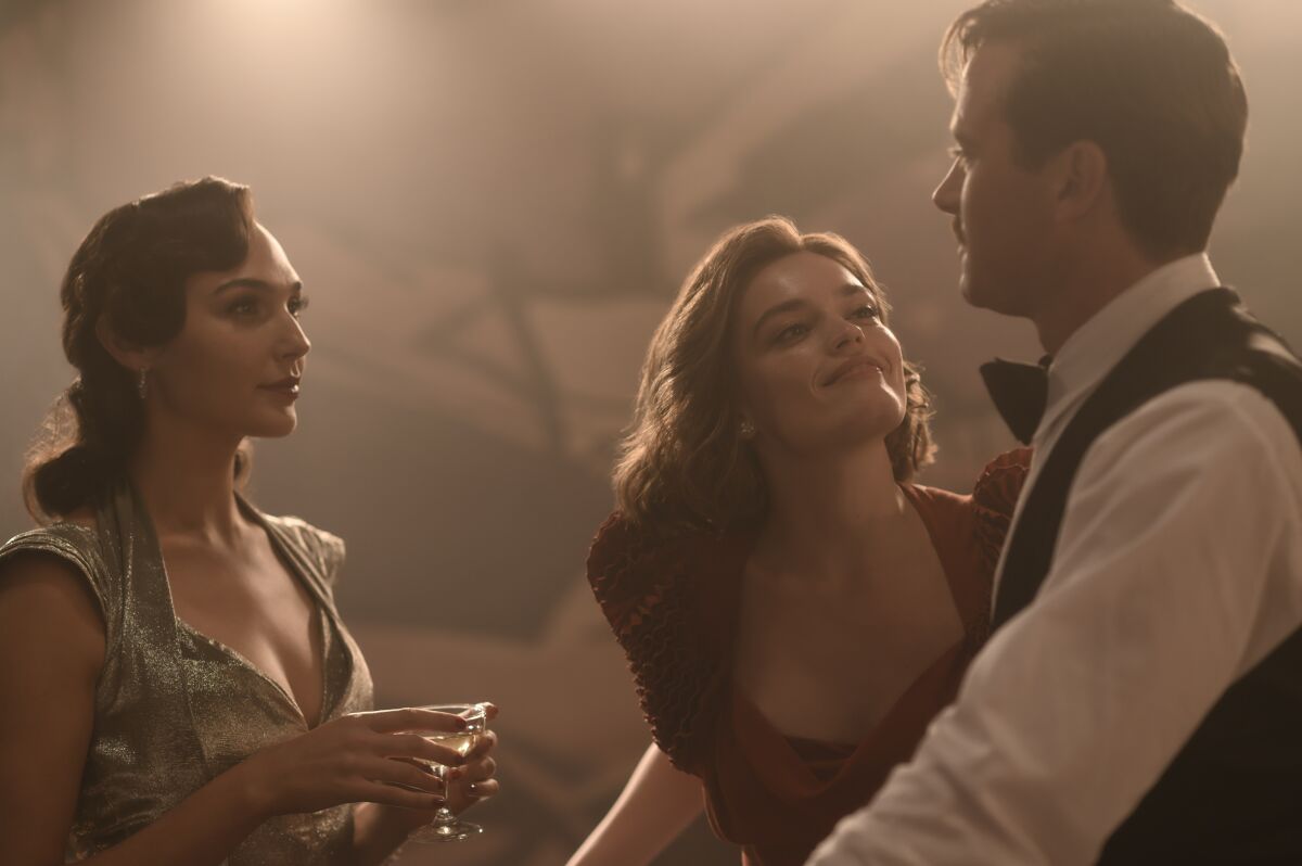Gal Gadot, Emma Mackey and Armie Hammer look at each other in a scene from "Death on the Nile."