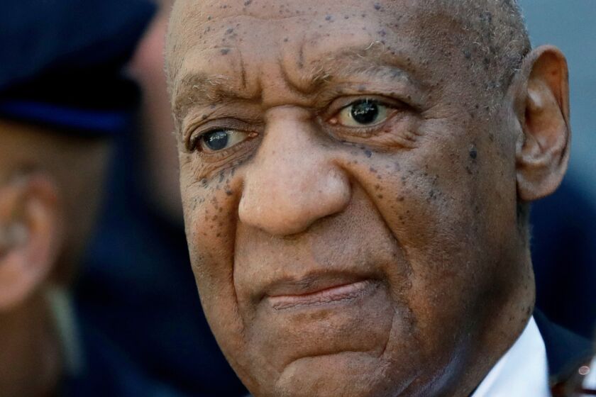 Bill Cosby stares off into space with pursed lips and a furrowed brow.