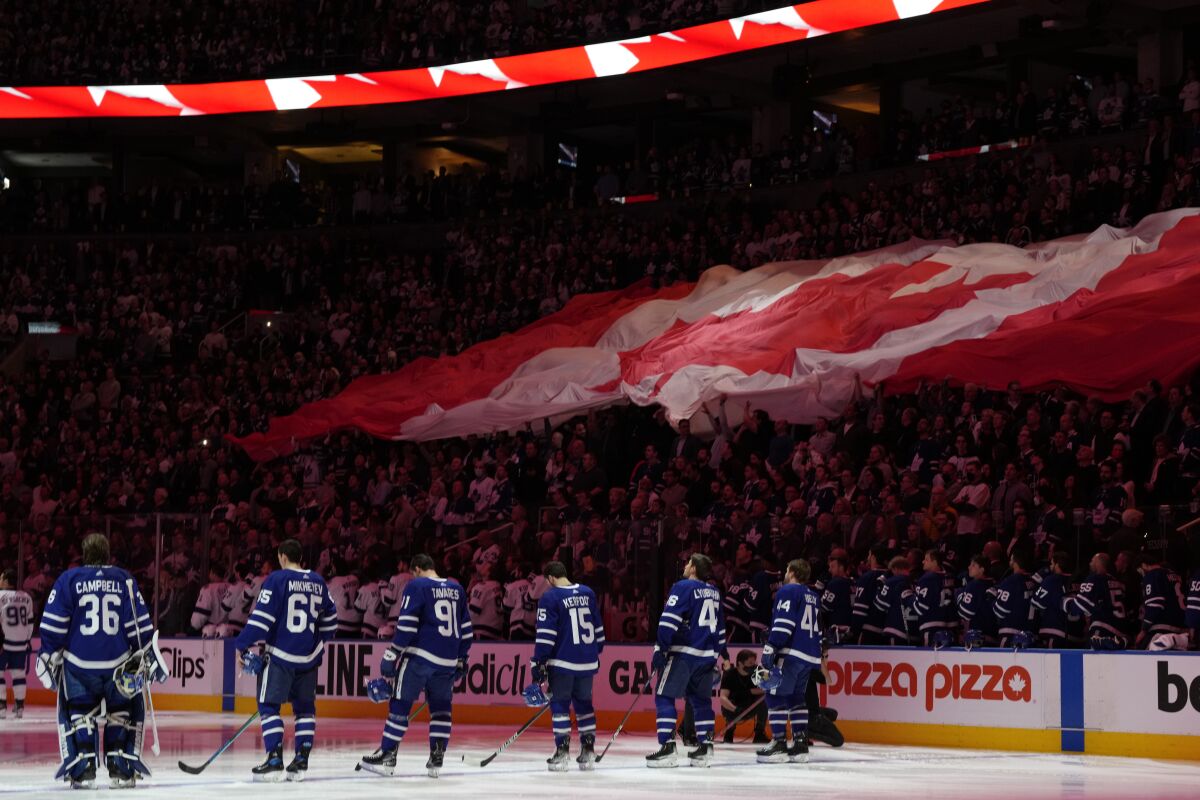 Fans and players stand for the national anthems before Game 2 of an NHL hockey Stanley Cup playoffs first-round series between the Tampa Bay Lightning and the Toronto Maple Leafs on Wednesday, May 4, 2022, in Toronto. (Frank Gunn/The Canadian Press via AP)