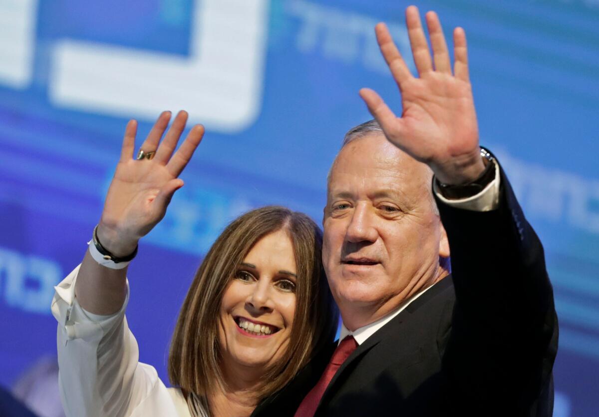 Benny Gantz. right, leader and candidate of the Israel Resilience party that is part of the Blue and White political alliance, waves to supporters alongside his wife, Revital Gantz, at the alliance's campaign headquarters in Tel Aviv on Sept. 18, 2019.