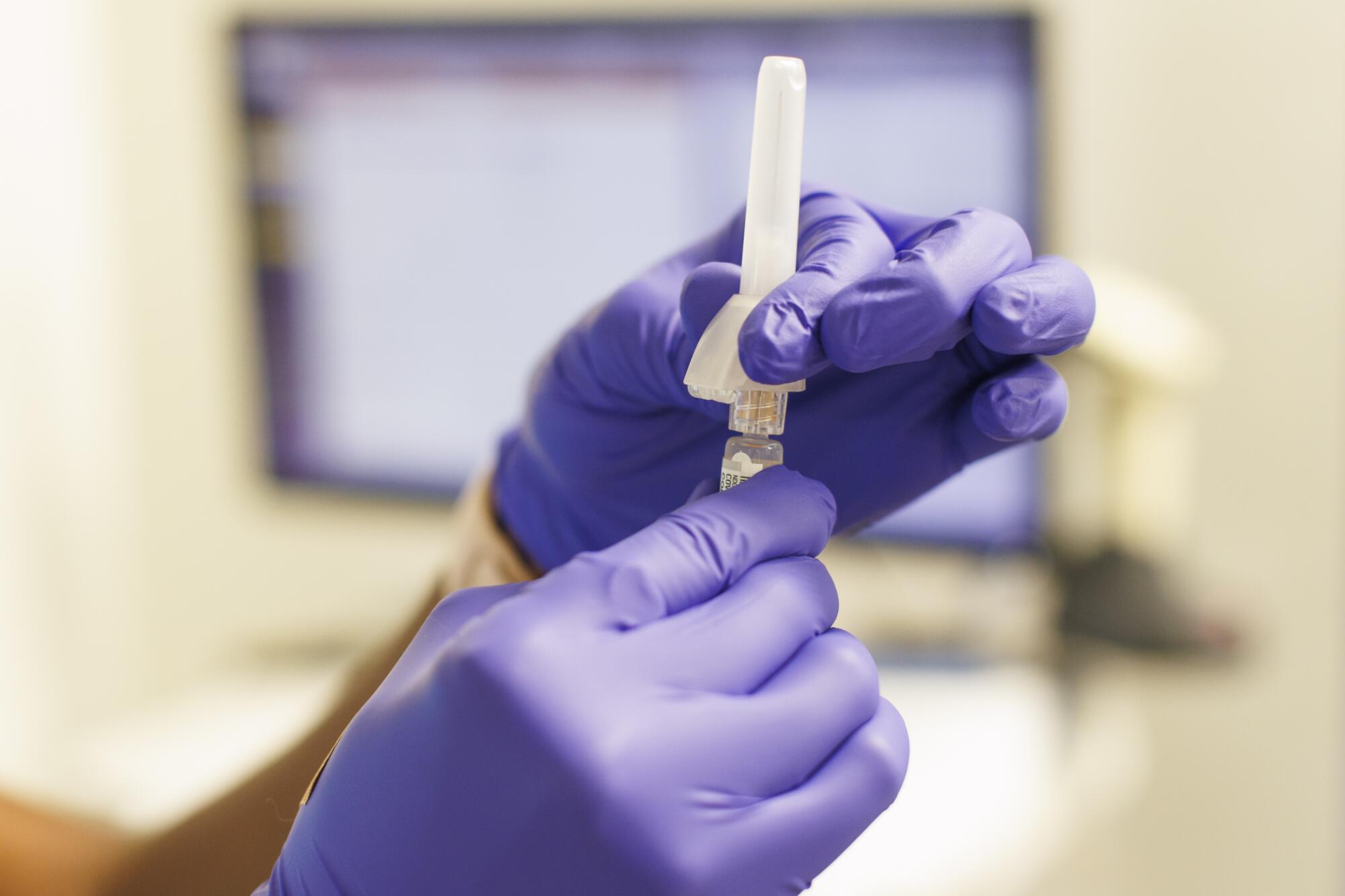 A nurse prepares a COVID-19 vaccination.