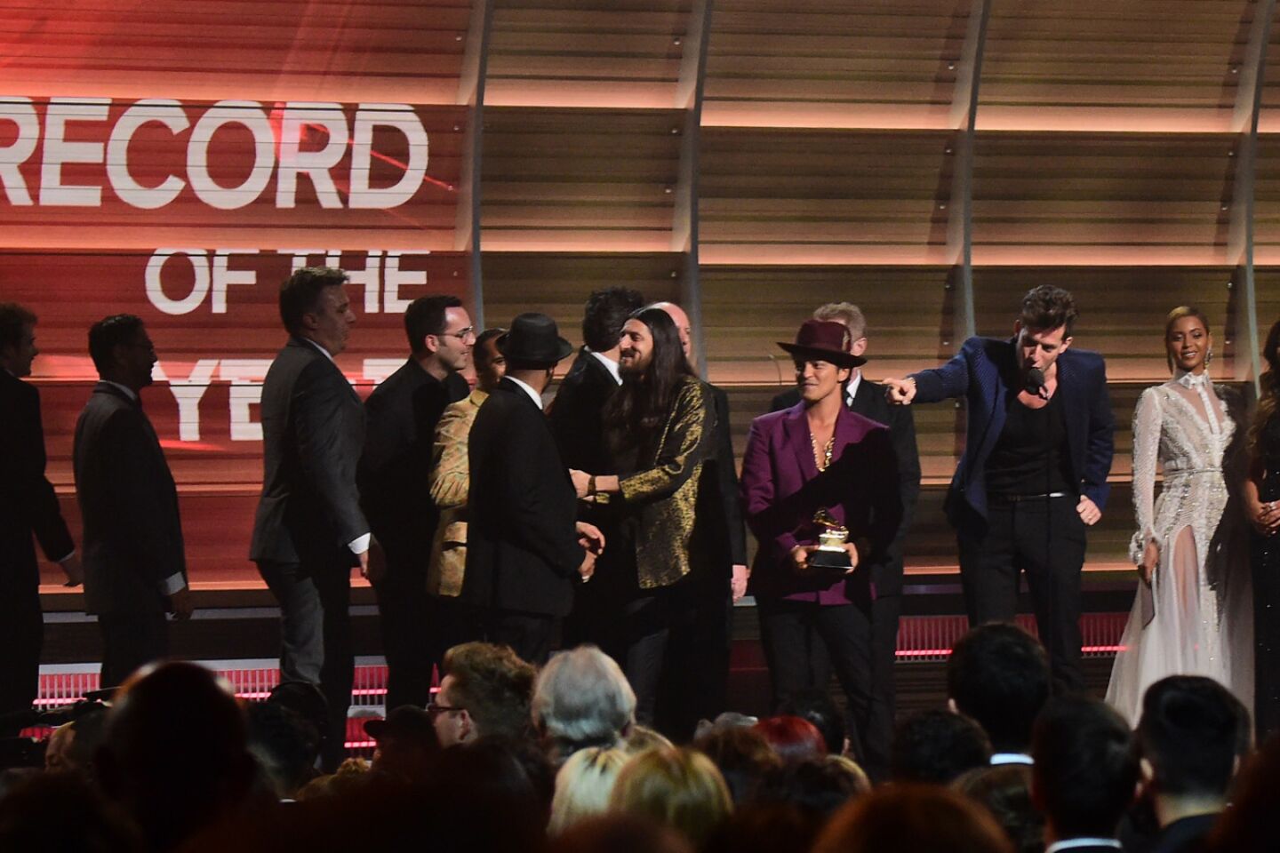 Mark Ronson accepts the award for the record of the year, for "Uptown Funk," with Bruno Mars, center.