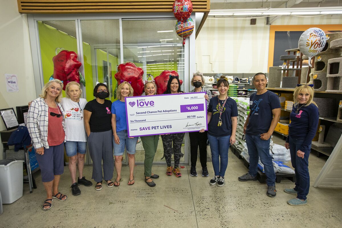 Second Chance volunteers and Petco employees pose for a photo Tuesday.