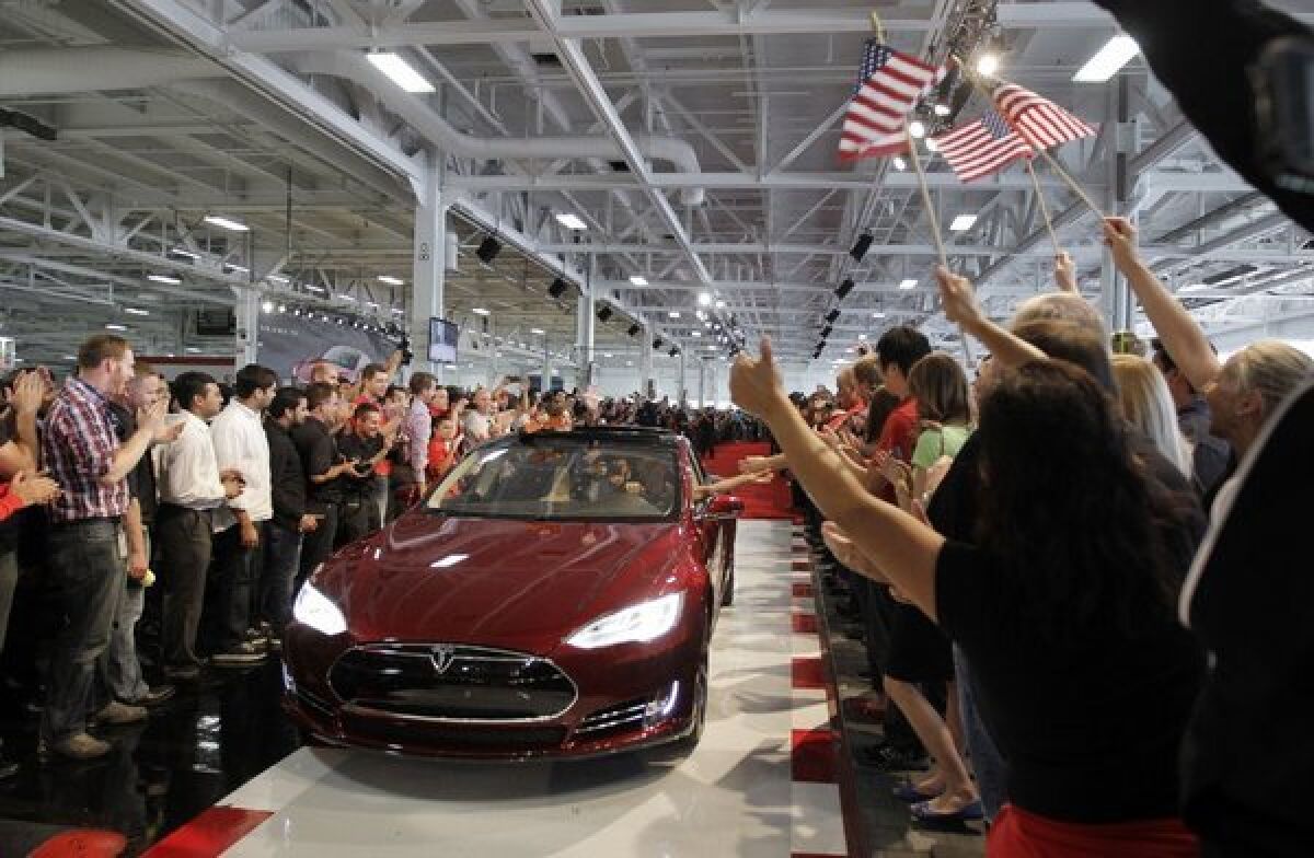 Tesla Motors Chief Executive Elon Musk has announced plans to accelerate a nationwide network of fast-charging stations for his company's electric cars, but some say he may be promising more than he can deliver. Above, Tesla workers cheer the sale of the first Tesla Model S sedan.