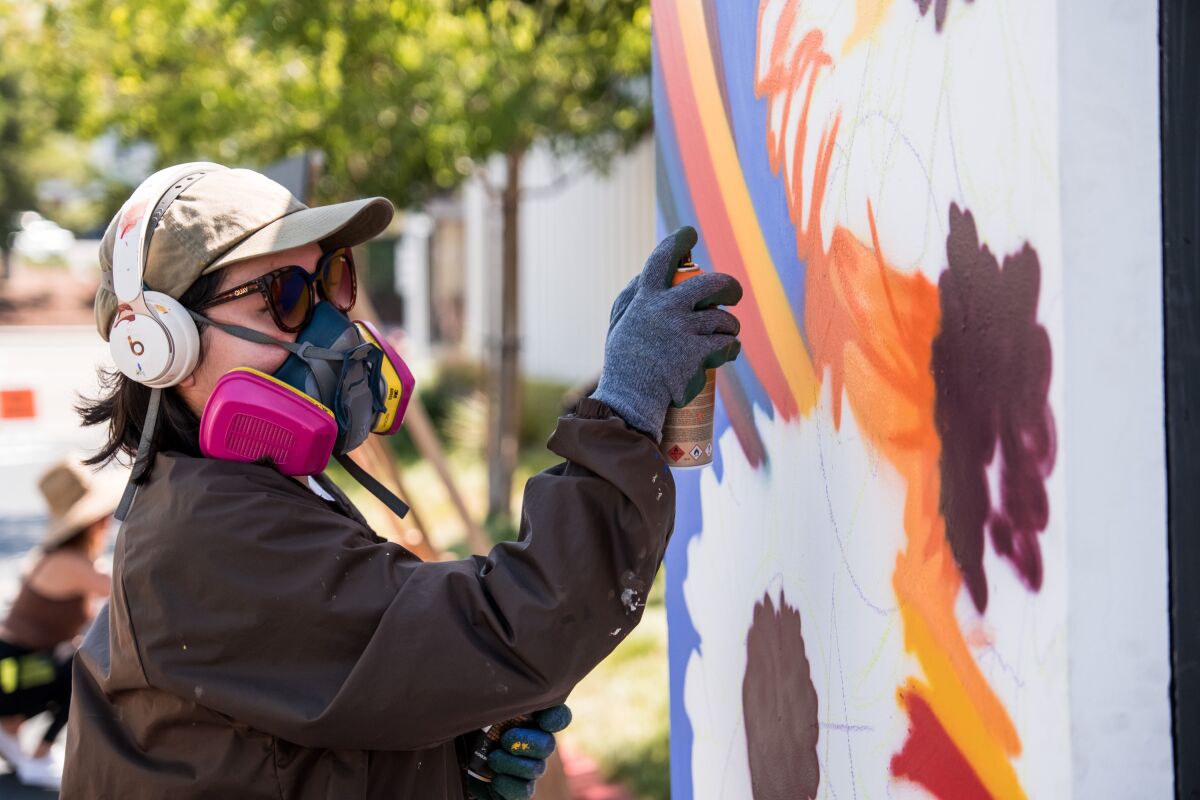 An artist works on a live art installation at One Paseo's previous Street Art Block Party, held September 2021.