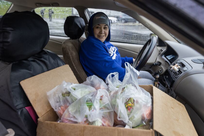 Los Angeles, CA - March 21: Leslie Ramirez picks up food for six kids for three days as workers distribute meals for students at a Grab & Go site at the Lincoln Park Recreation Center in Los Angeles Tuesday, March 21, 2023. Six meals per student are provided at pickup, to cover breakfast and lunch over three days. The massive three-day strike begins, with LAUSD teachers, bus drivers, custodians and other workers shutting down Los Angeles public schools. (Allen J. Schaben / Los Angeles Times)