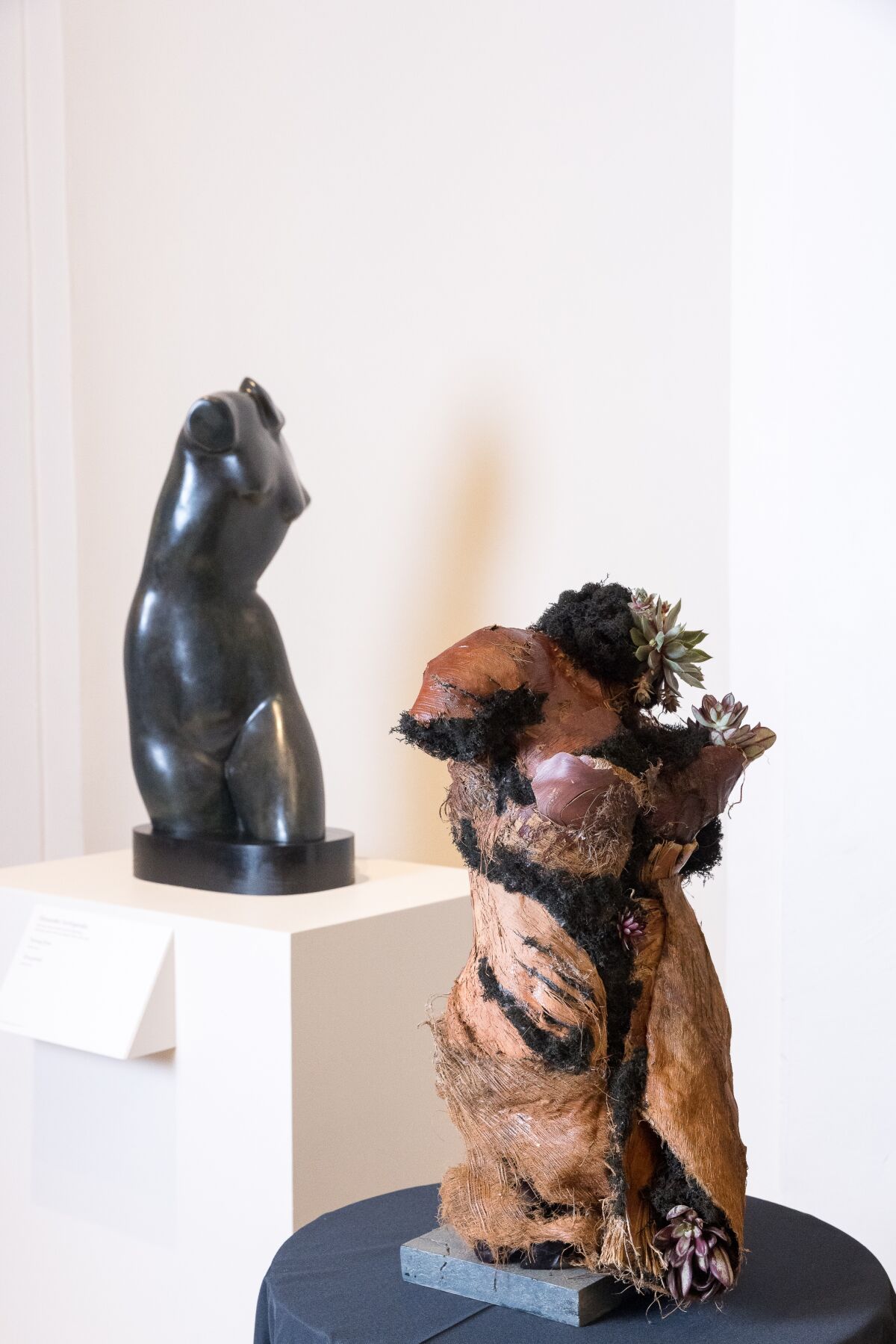 A floral arrangement sits next to a sculpture that inspired it