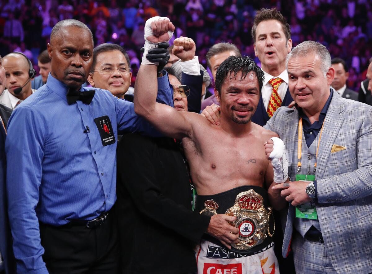 Manny Pacquiao, center, celebrates as referee Kenny Bayless holds up his hand, signaling his victory.