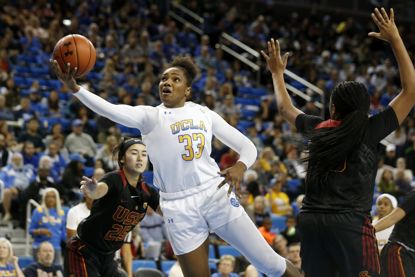 UCLA forward Lauryn Miller scores between USC guard Alyson Miura (25) and center Angel Jackson (15) during the second half.