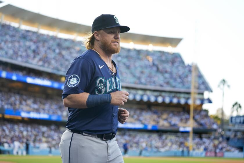 Seattle Mariners' Justin Turner walks back to the dugout after being honored.