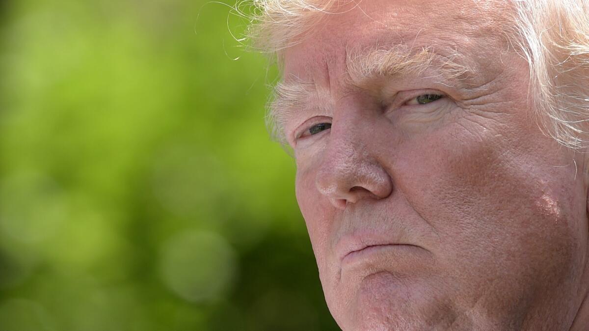 President Trump listens in the White House Rose Garden in Washington on June 9.