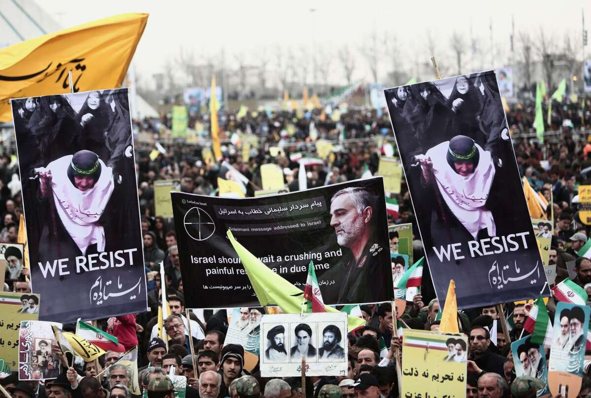 Iranian demonstrators hold a portrait of Iranian commander Major Gen. Qassem Suleimani, who has been advising Iraqi military leaders fighting Islamic jihadists, during a rally to mark the 36th anniversary of the Islamic revolution in Tehran's Freedom Square on Feb. 11.
