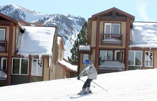 A skier glides by the Eagle Run condos in Mammoth Mountain.