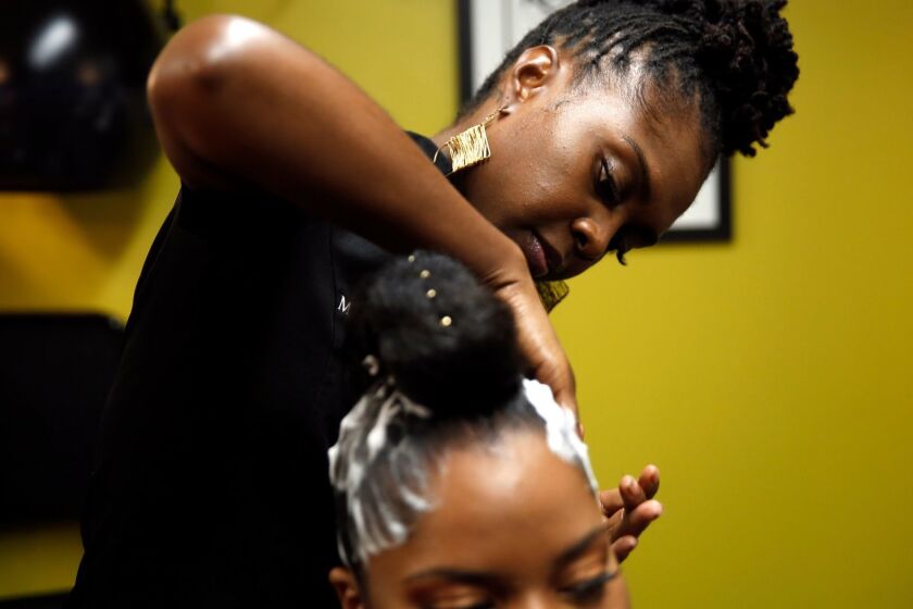 LOS ANGELES, CA-JUNE 22, 2019: Dr. Kari Williams, founder of Mahogany Hair Revolution and a member of the California Board of Barbering and Cosmetology, works on Rosie Smith's hair at her studio on June 22, 2019 in Los Angeles, California. Williams' supports the Crown Act, a piece of legislation that would ban hair discrimination in California and put an end to policies that punish black employees and students for their hairstyles. (Photo By Dania Maxwell / Los Angeles Times)