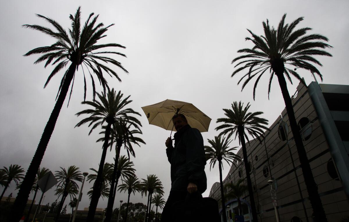 A pedestrian walks in Long Beach during heavy rain on Dec. 12.