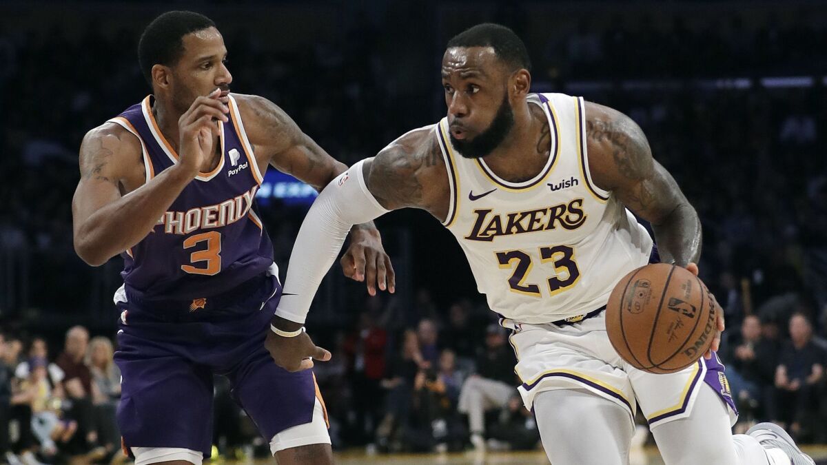 Lakers' LeBron James (23) drives against Phoenix Suns' Trevor Ariza (3).