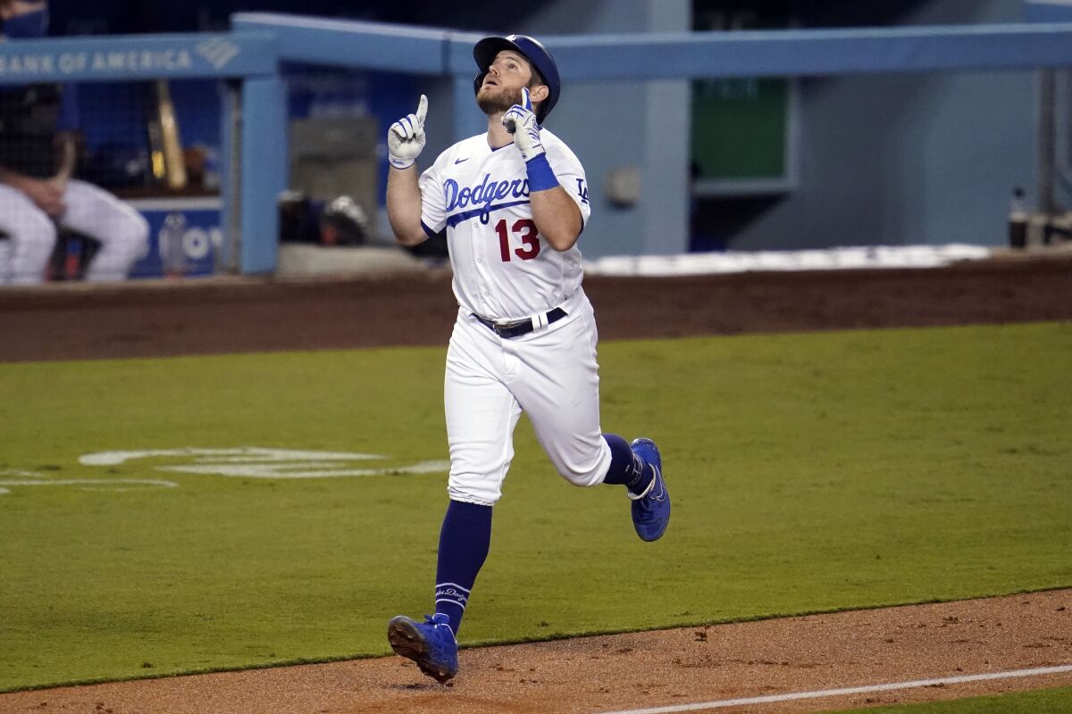 Dodgers' Max Muncy points to the sky as he nears home plate after hitting a two-run home run against Oakland on Sept. 23.