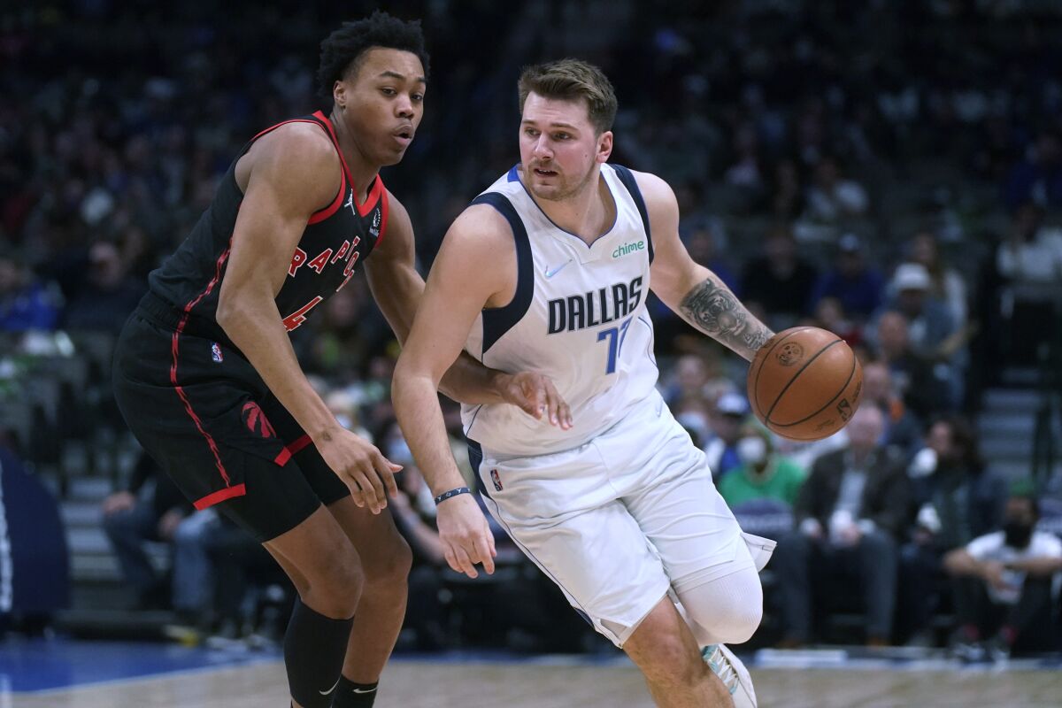 Dallas Mavericks center Dwight Powell (7) drives against Toronto Raptors forward Scottie Barnes (4) during the first quarter of an NBA basketball game in Dallas, Wednesday, Jan. 19, 2022. (AP Photo/LM Otero)