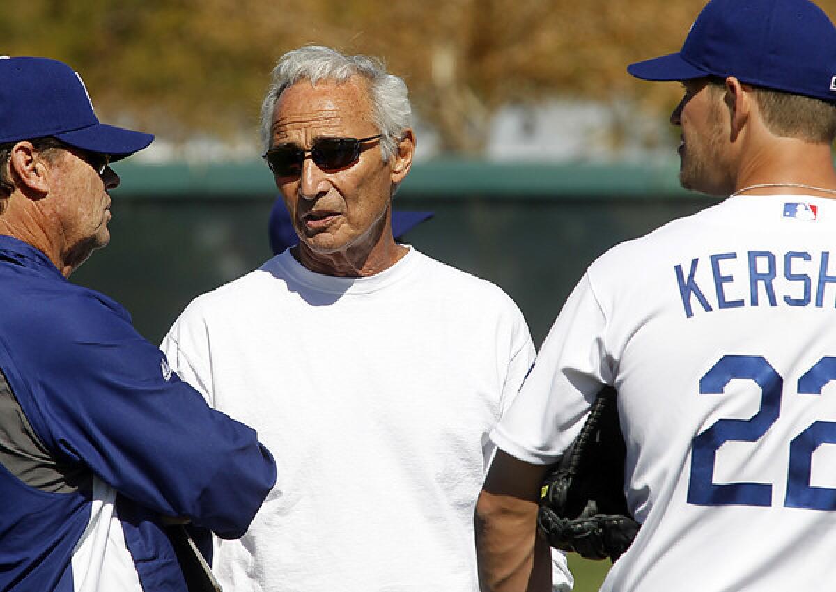 Former Dodger great Sandy Koufax chats with pitching coach Rick Honeycutt and ace Clayton Kershaw during spring training last year.