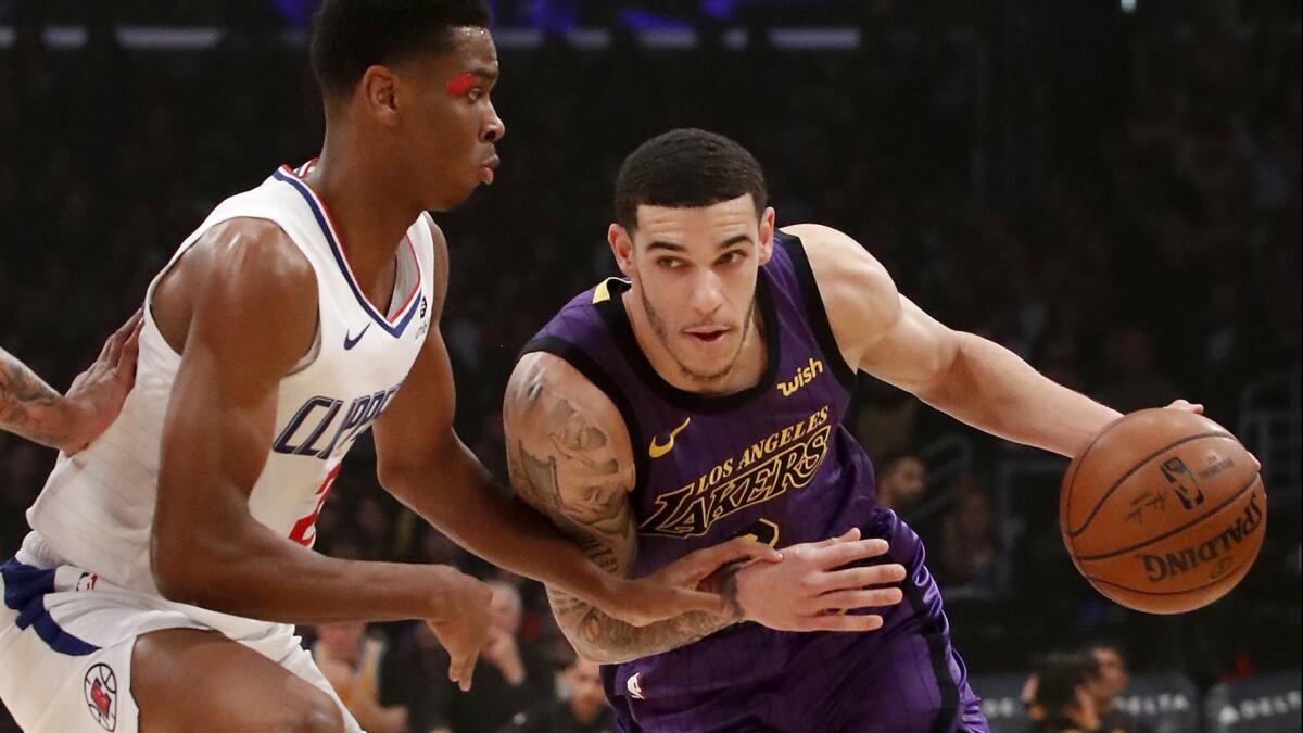 Lakers guard Lonzo Ball drives to the basket against Clippers guard Shai Gilgeous-Alexander in the first quarter on Friday at Staples Center.