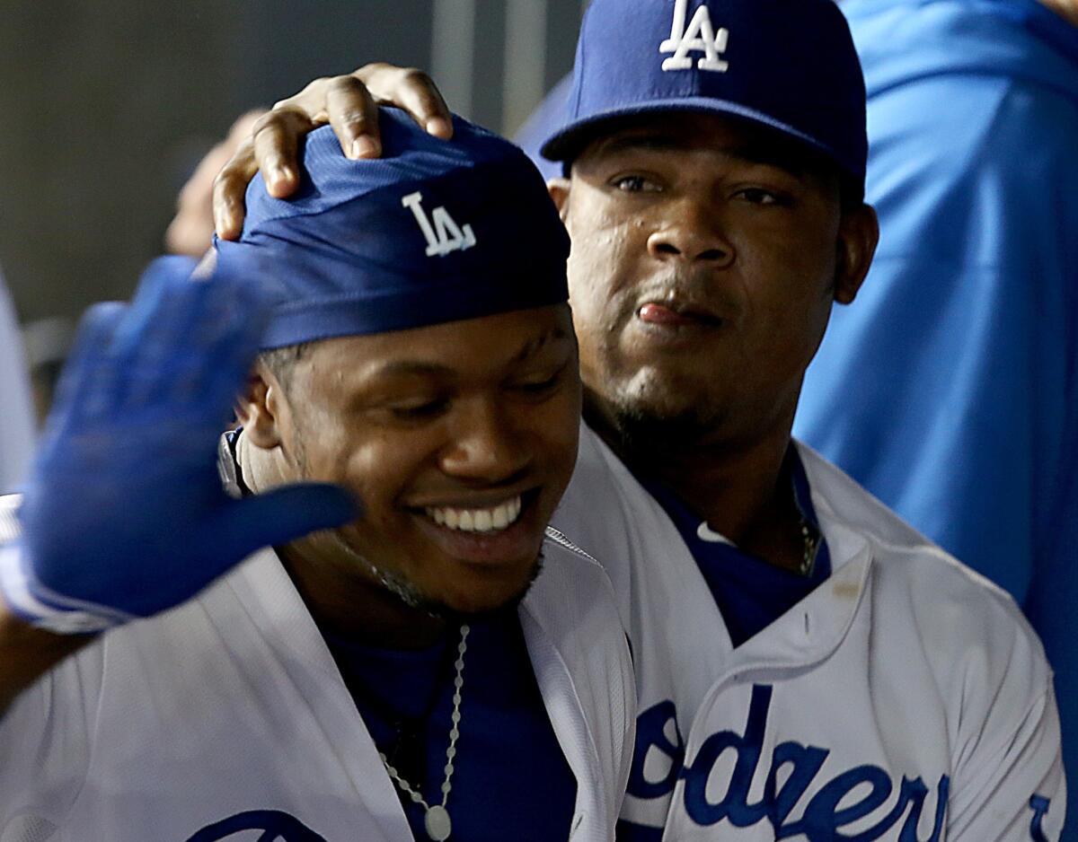 Dodgers shortstop Hanley Ramirez, left, is congratulated by third baseman Juan Uribe after hitting a solo home run against the Chicago Cubs on Aug. 26. Neither player will start Tuesday against the Colorado Rockies.