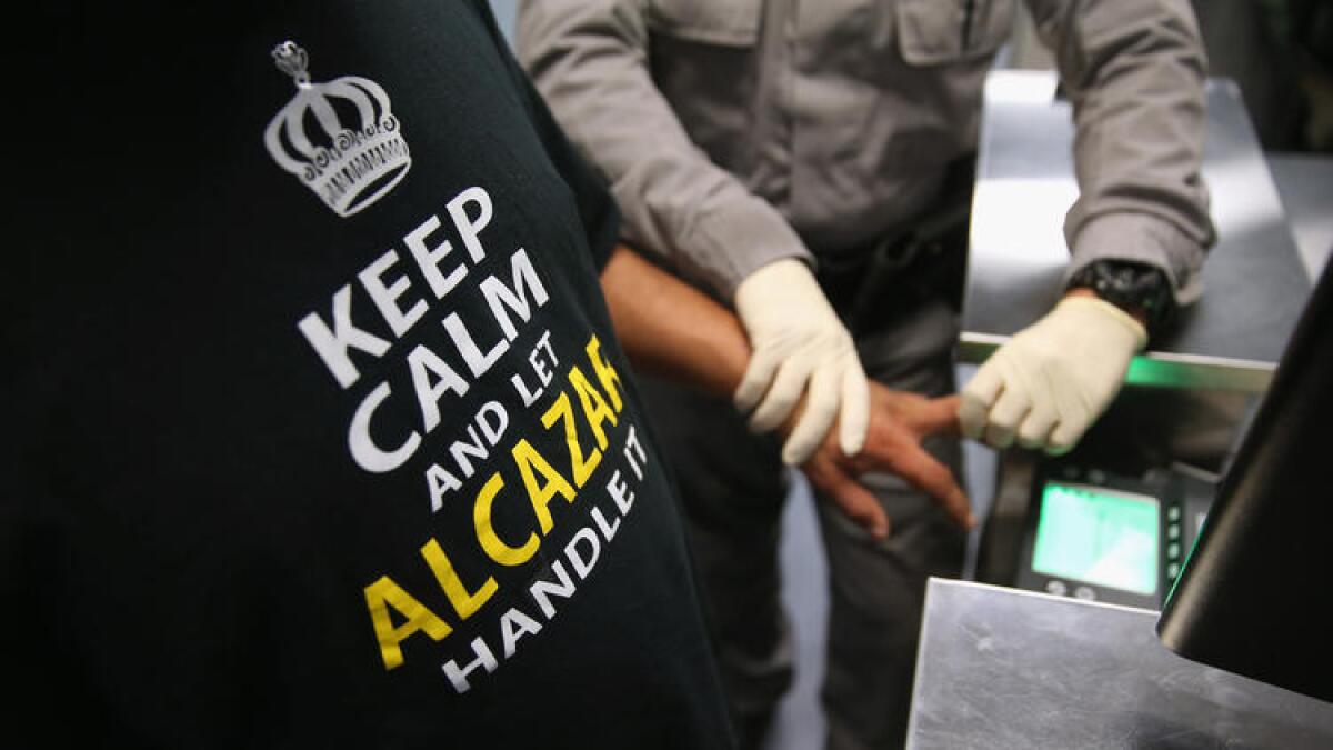 Un agente de Inmigración y Aduanas de los Estados Unidostoma las huellas dactilares de un inmigrante detenido en un centro de procesamiento de ICE en Camarillo este mes.