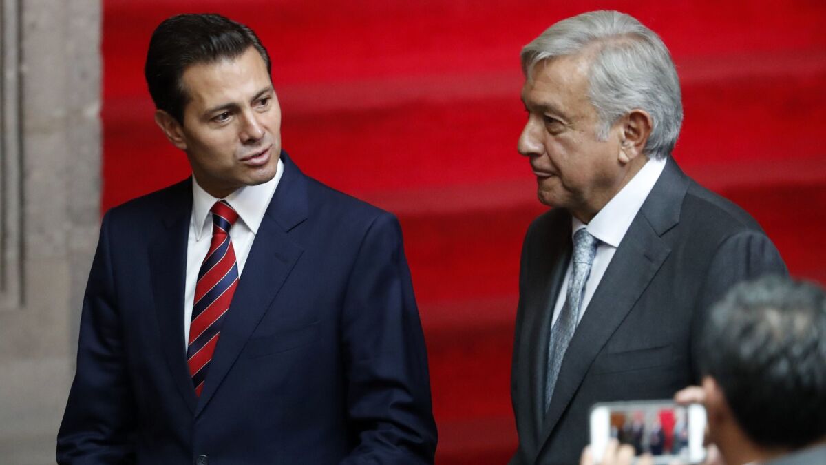 Mexican President Enrique Peña Nieto, left, and President-elect Andres Manuel Lopez Obrador talk at the National Palace in Mexico City, on Aug. 20, 2018.