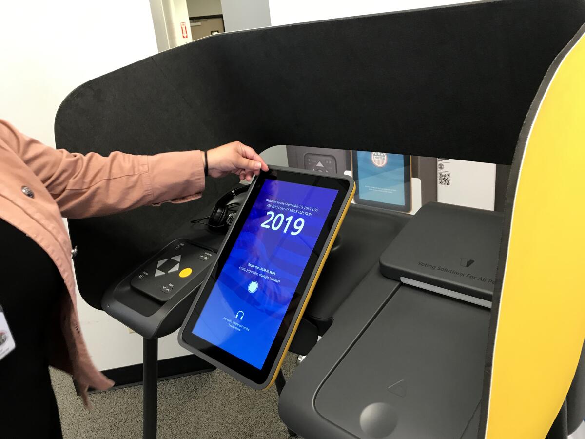 A county registrar staffer in Norwalk shows off the touch screen on one of Los Angeles County's interactive ballot-marking machines.