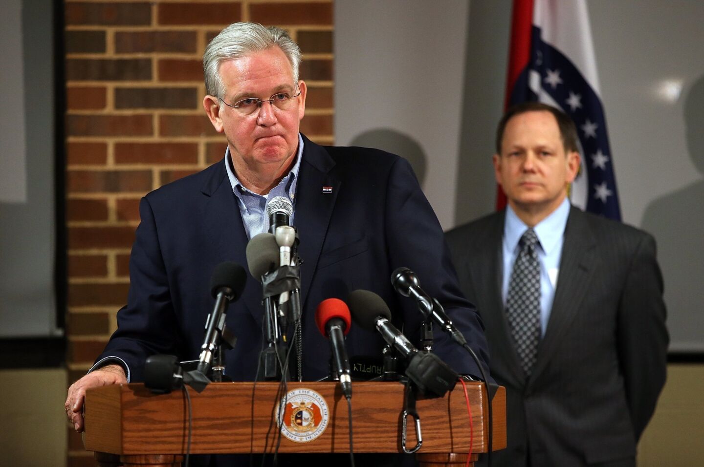 Missouri Gov. Jay Nixon speaks during a news conference as St. Louis Mayor Francis Slay looks on at the University of Missouri, St. Louis. Nixon asked for calm in the community amid the news that a grand jury has reached a decision on whether to charge Ferguson Officer Darren Wilson.