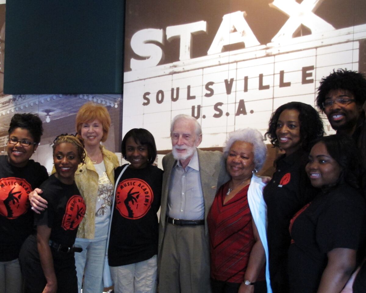 FILE - Stax Records founder Jim Stewart, center, poses for a photo with friends and students of the Stax Music Academy on April 29, 2013 in Memphis, Tenn. Stewart, the white Tennessee farm boy and fiddle player who co-founded the influential Stax Records in a Black, inner-city Memphis neighborhood and helped build the soulful “Memphis sound,” died Monday, Dec. 5, 2022, at age 92. (AP Photos/Adrian Sainz, File)