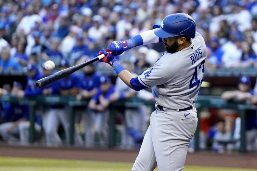 Los Angeles Dodgers' Edwin Rios, left, connects for a three-run home run as Arizona Diamondbacks.