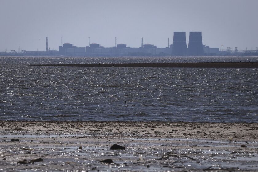 The Zaporizhzhia nuclear power plant, Europe's largest, is seen in the background of the shallow Kakhovka Reservoir after the dam collapse, in Energodar, Russian-occupied Ukraine, Friday, June 9, 2023. The plant has been under Russian occupation since 2022. (AP Photo/Kateryna Klochko)