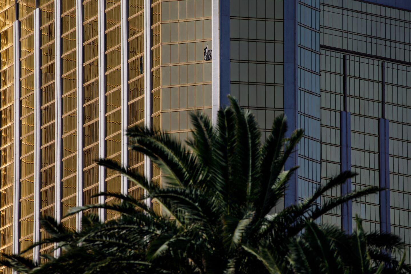A curtain blows out of a broken window at the Mandalay Bay Resort and Casino, from where a gunman targeted a a country music festival across the street on the Las Vegas Strip on Sunday night.