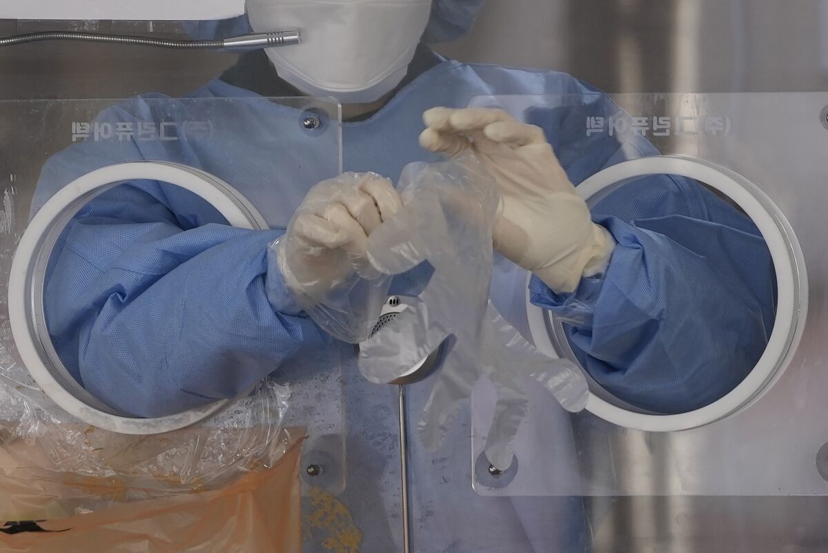 A medical worker wears plastic gloves at a temporary coronavirus screening clinic in Seoul.