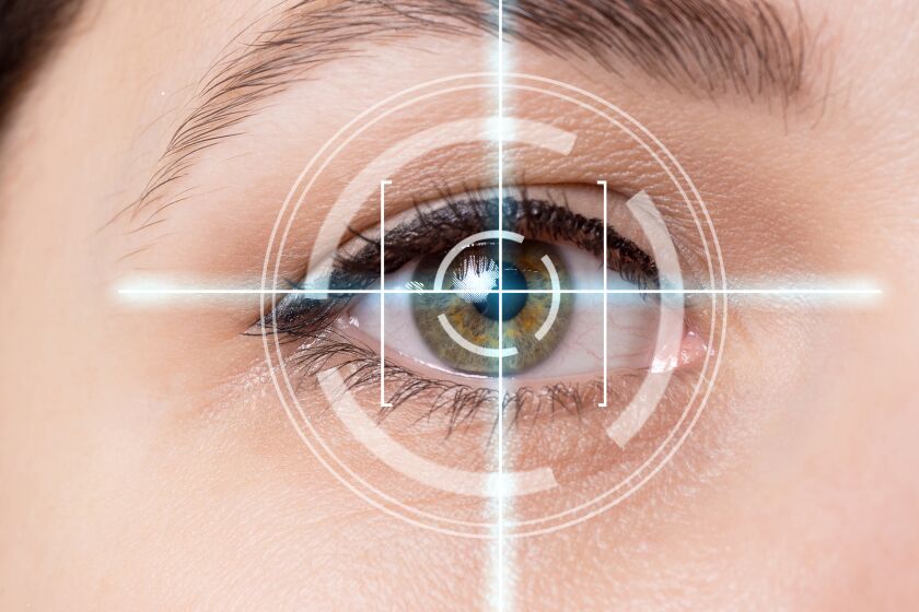 Laser scanning of female eye on blue background.