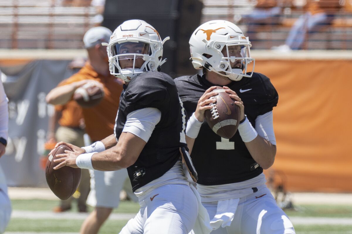 FILE - In this April 24, 2021, file photo, Texas quarterbacks Casey Thompson, left, and Hudson Card warm up before the Texas Orange and White Spring NCAA college football game in Austin, Texas. First-year Texas coach Steve Sarkisian is already shuffling starters, replacing inconsistent redshirt freshman Hudson Card with junior Casey Thompson with the Longhorns already unranked. (AP Photo/Michael Thomas, File)