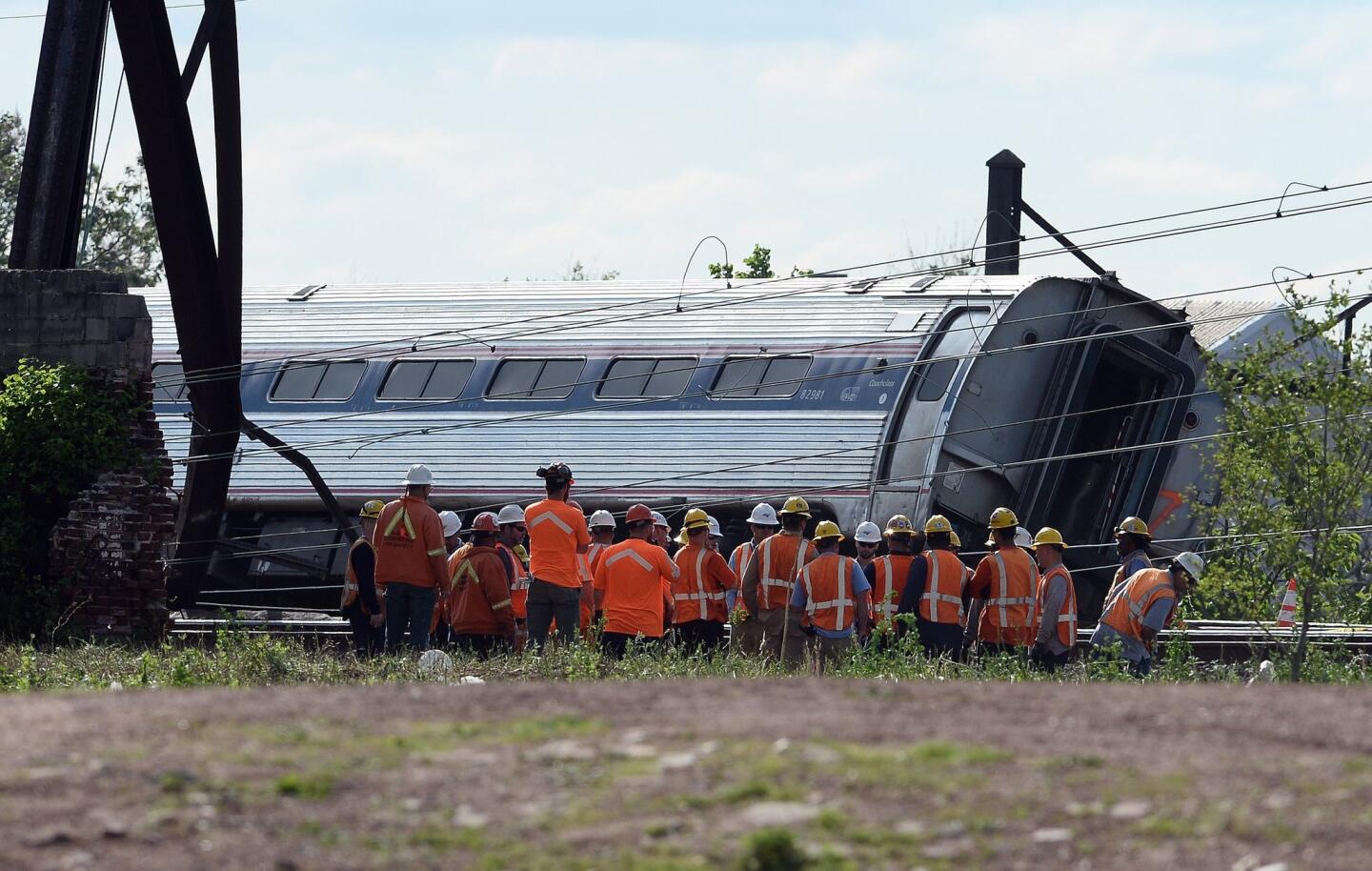 Rescuers stand near a derailed carriage of an Amtrak train in Philadelphia on May 13, 2015.