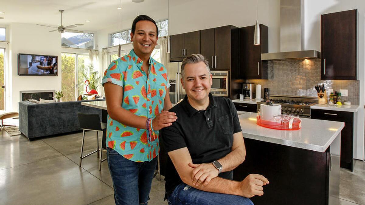 Ross Mathews, seated, and Salvador Camarena entertain friends and family in their open-plan kitchen/living/dining space. (Irfan Khan / Los Angeles Times)