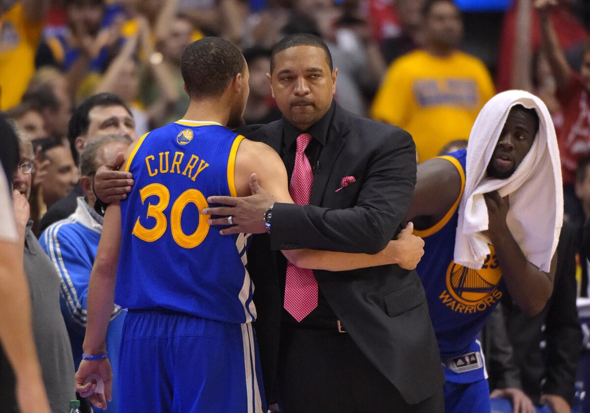 Warriors head coach Mark Jackson hugs guard Stephen Curry after he was taken out of a playoff game against the Clippers.