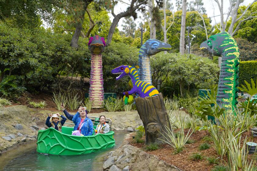Carlsbad, CA - March 22: At Legoland California on Friday, March 22, 2024 in Carlsbad, CA, a family enjoys the boat ride down Explorer River Quest during the grand opening for Legoland’s newest area, Dino Valley. (Nelvin C. Cepeda / The San Diego Union-Tribune)