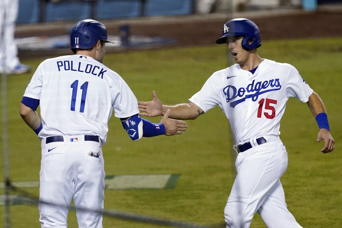 Dodgers' AJ Pollock welcomes Austin Barnes home after both scored in the fifth inning.