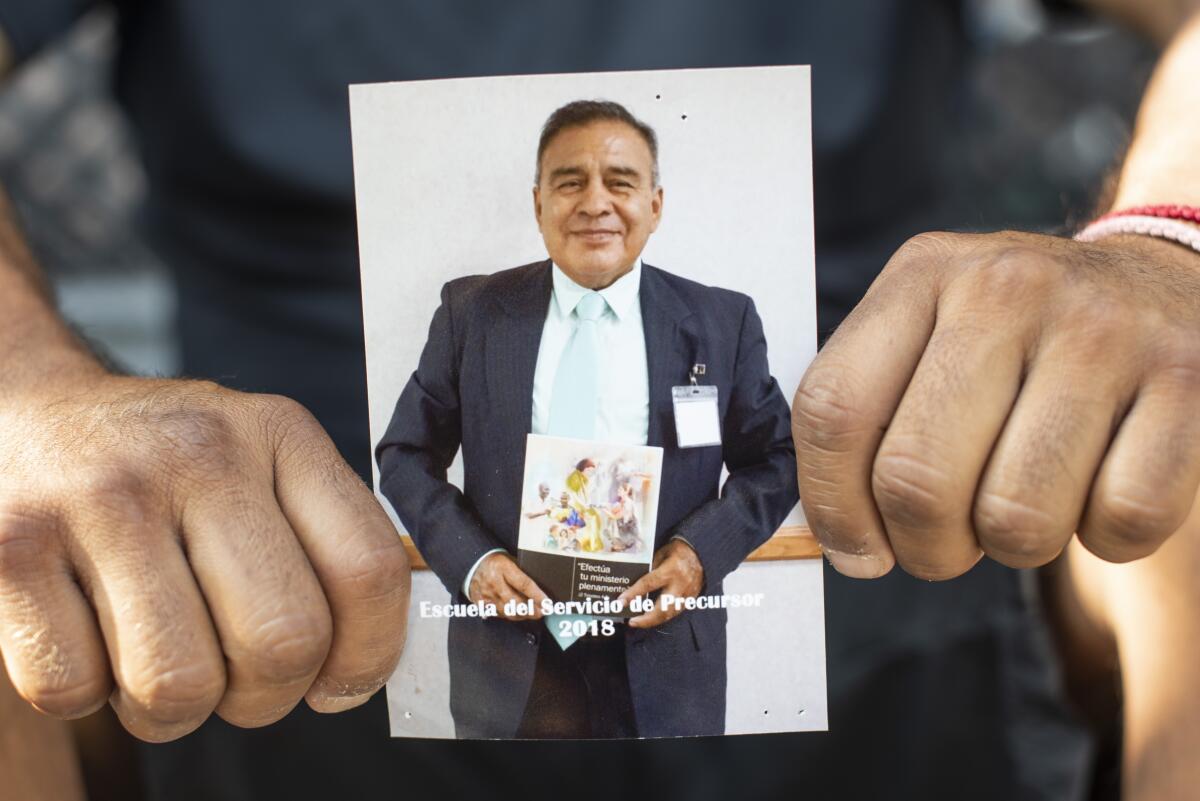 Jaime Samano holds a photo of his father