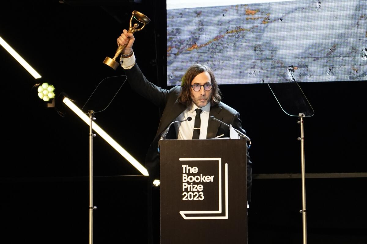 Paul Lynch holding up his 2023 Booker Prize trophy