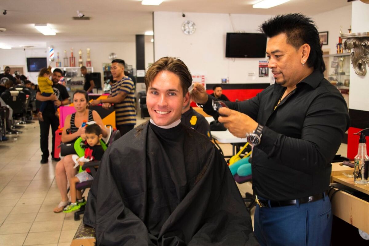Miles Himmel gets a trim from barber college owner Danny Nguyen during the 2019 back-to-school event. 