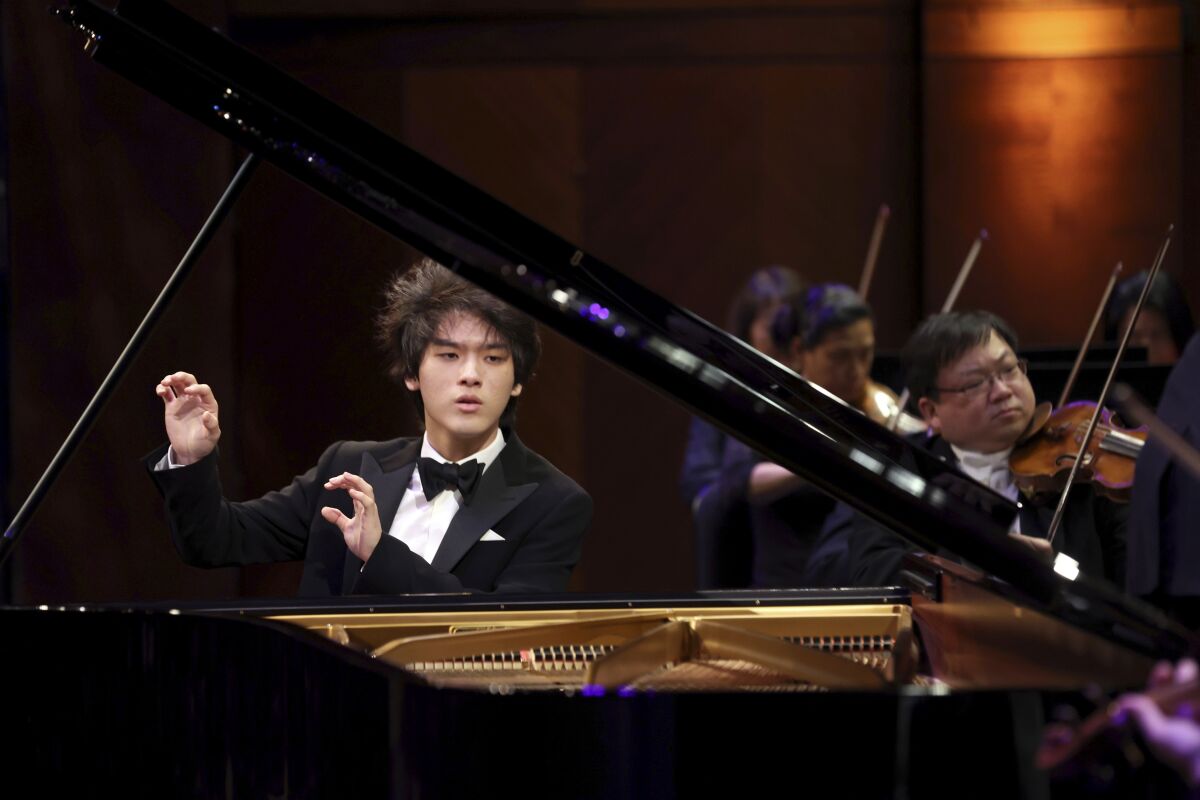 In this photo provided by The Cliburn, Yunchan Lim, of South Korea, performs a concerto with the Fort Worth Symphony Orchestra conducted by Chairman of the Jury Marin Alsop in the final round of the 16th Van Cliburn International Piano Competition at Bass Performance Hall in Fort Worth, Texas, on June 12, 2022. The 18-year-old has won the competition, one of the top showcases for the world's best pianists. (Richard Rodriguez/The Cliburn via AP)