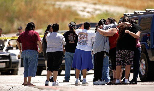 Grieving family members comfort each other at the reservation of the Soboba Band of Luiseno Indians where a man and woman were killed in a shootout with Riverside County sheriff's deputies Monday evening. Authorities said the pair opened fire on guards at an entrance, then fled into the reservation, where they were killed by deputies. The two were tribal members: 36-year-old Joseph Arres and an unidentified woman. Tribal Chairman Robert Salgado said Tuesday that the Sheriff's Department's reaction was overkill.