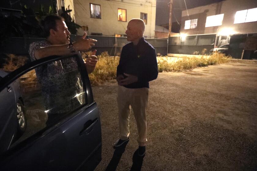 HOLLYWOOD, CA - OCTOBER 10, 2023 - Saul, 55, left, talks with Safe Parking co-founder Scott Sale, MD, before bedding down for the night in his car at a Safe Parking lot in Hollywood on October 10, 2023. Saul, who only wanted to give his first name, has been living homeless in his car since July 2021. He covers the windows of his car with plastic black trash bags to keep the light out so he can sleep. "You don't know where it ends," said Saul about his homeless situation. "I could end up here indefinitely," he concluded. In the latest census, about 44% of participants of the Safe Parking program were 55 and older, while 21% were 62 and older. (Genaro Molina / Los Angeles Times)