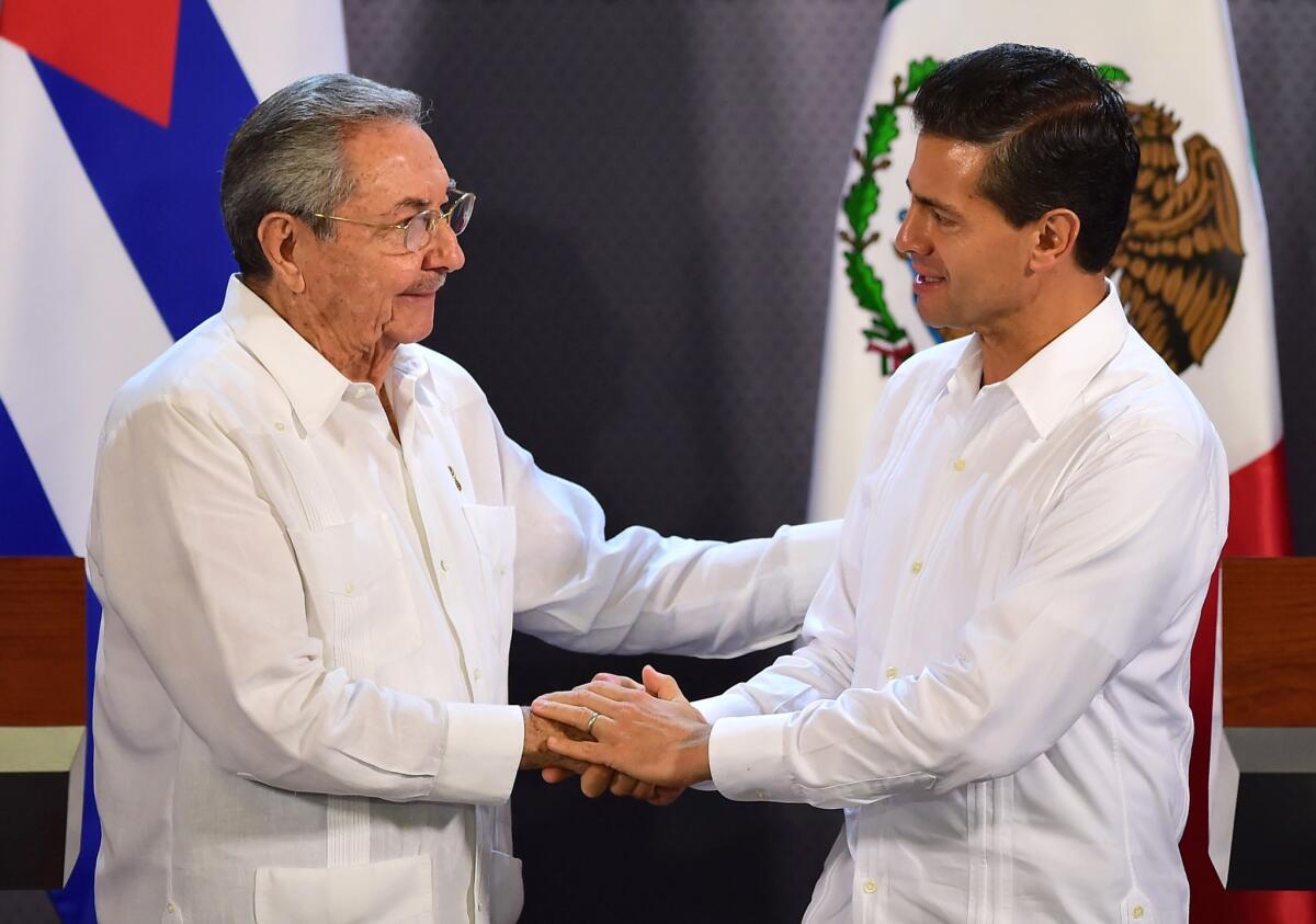 Mexican President Enrique Peña Nieto, right, and Cuban President Raul Castro shake hands during a news conference at the government palace in Merida, Mexico, on Nov. 6.