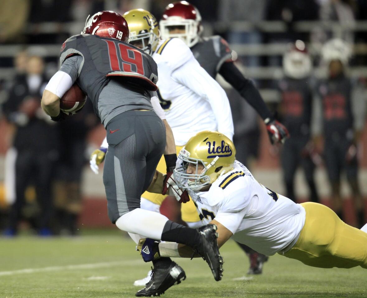 UCLA linebacker Ryan Hofmeister tackles Washington State receiver Brett Bartolone after a reception in the first quarter Saturday night.