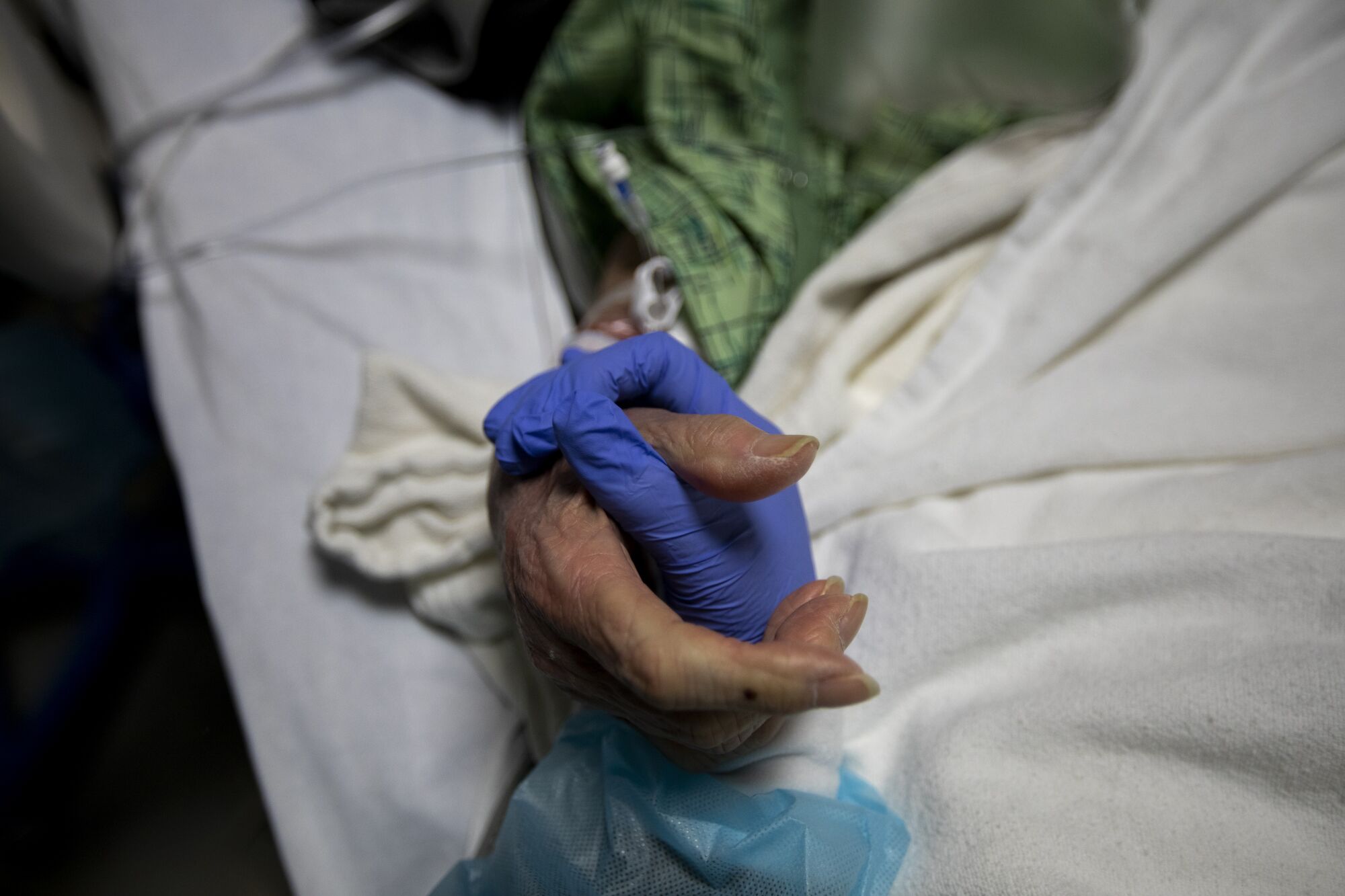 A nurse holds a patient's hand